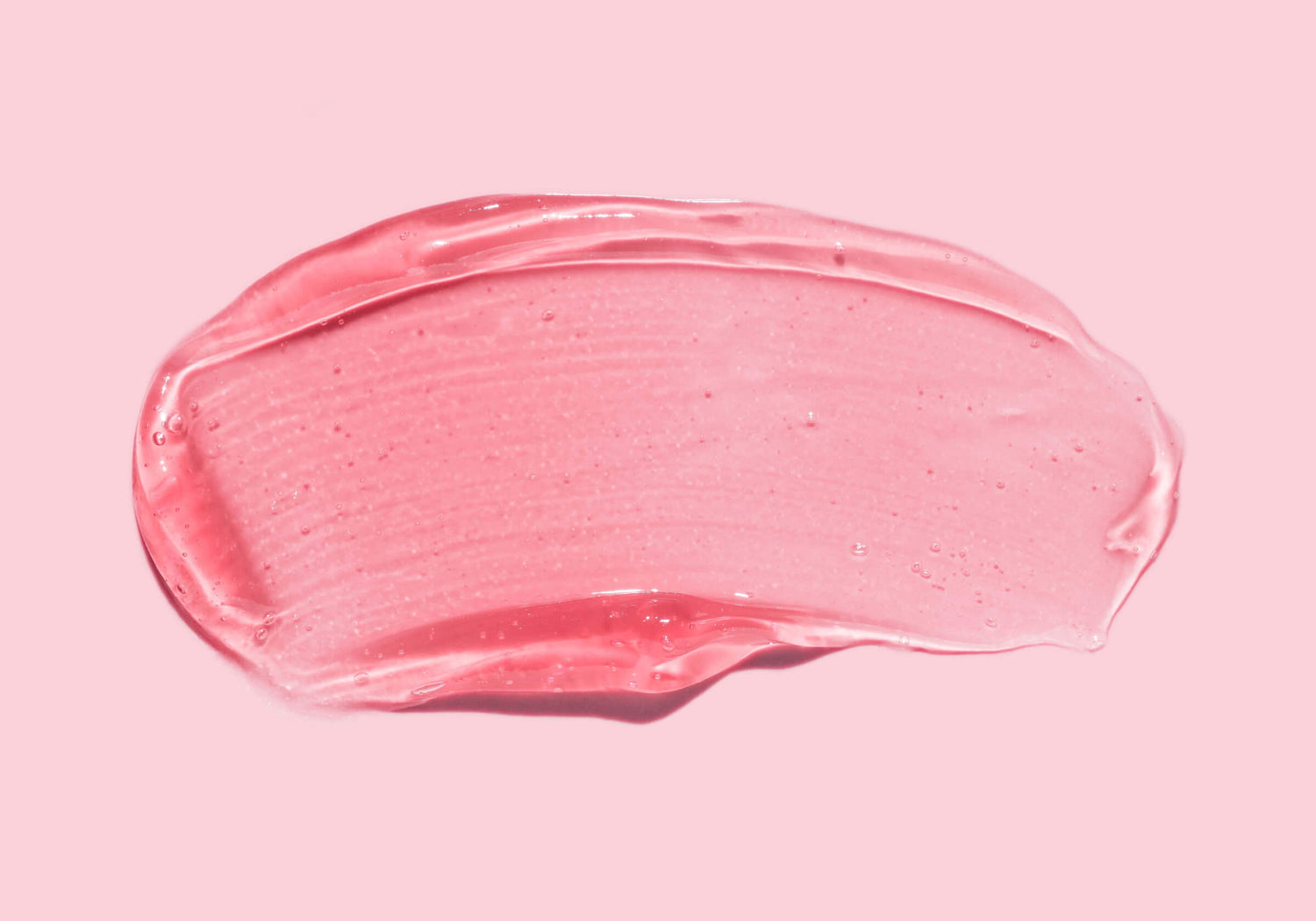 A type of acid is spread in gel form on a pink background. Learn more about exfoliating acids.